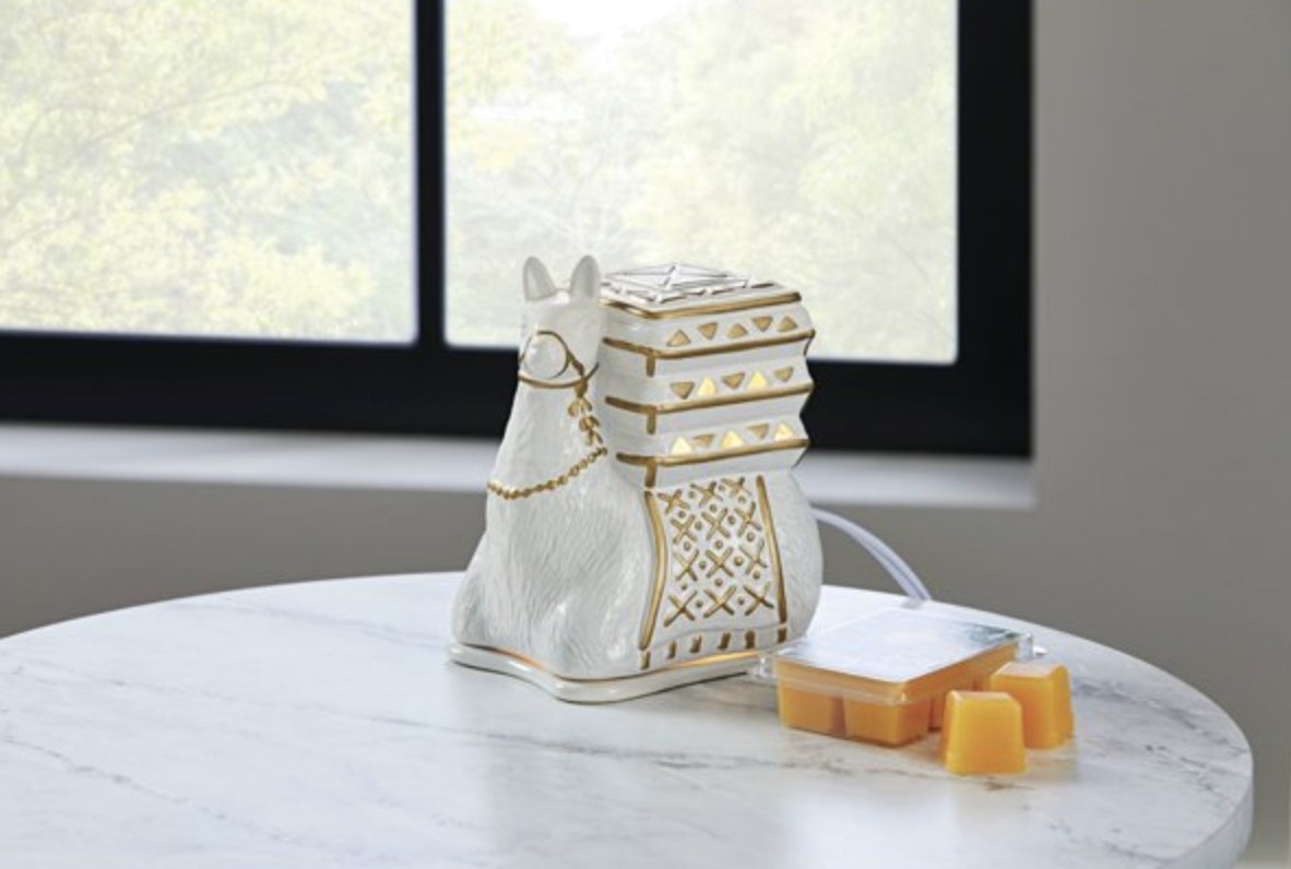 a white llama with gold accents that is actually a wax melter