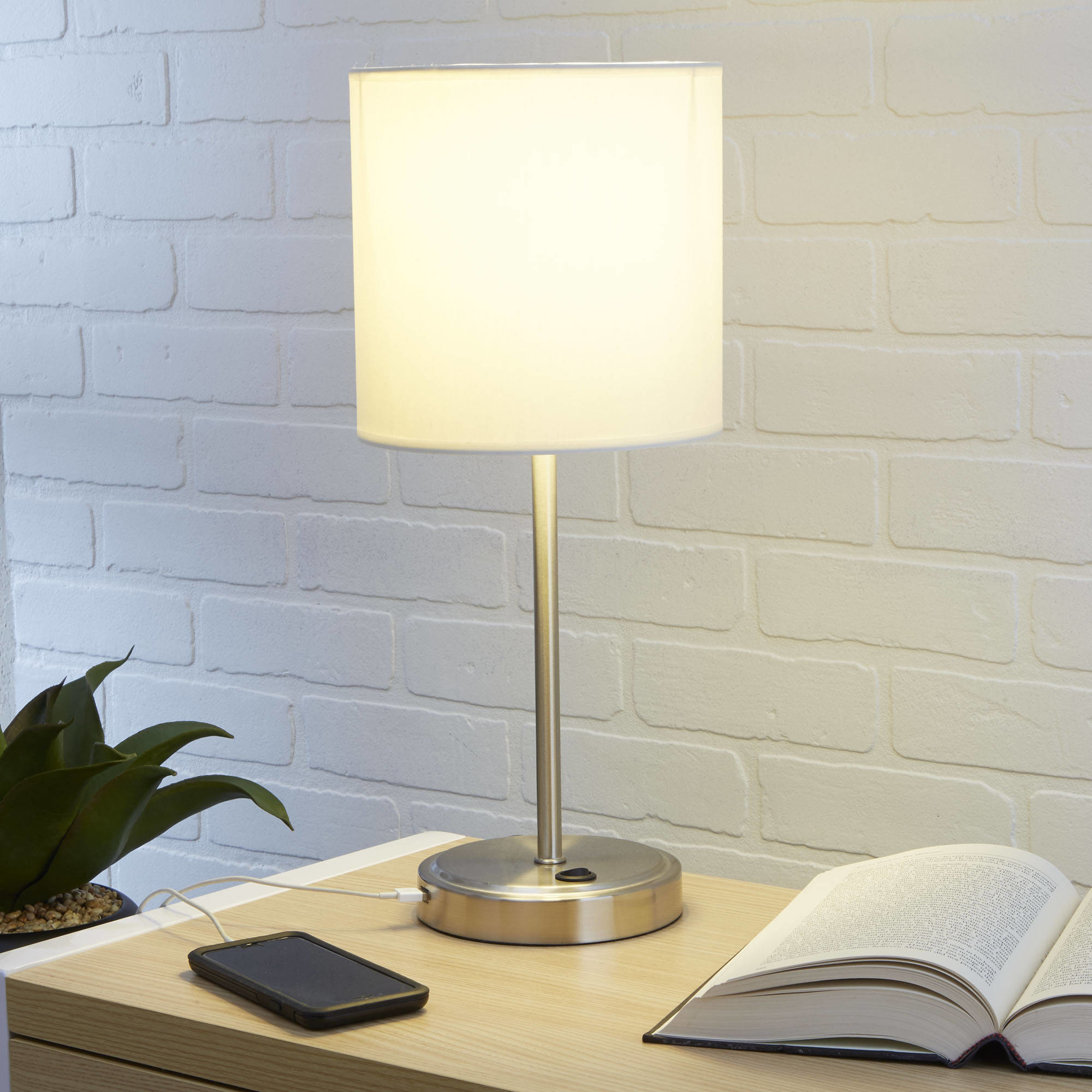 a silver lamp with a white shade and a place to plug in a usb cable