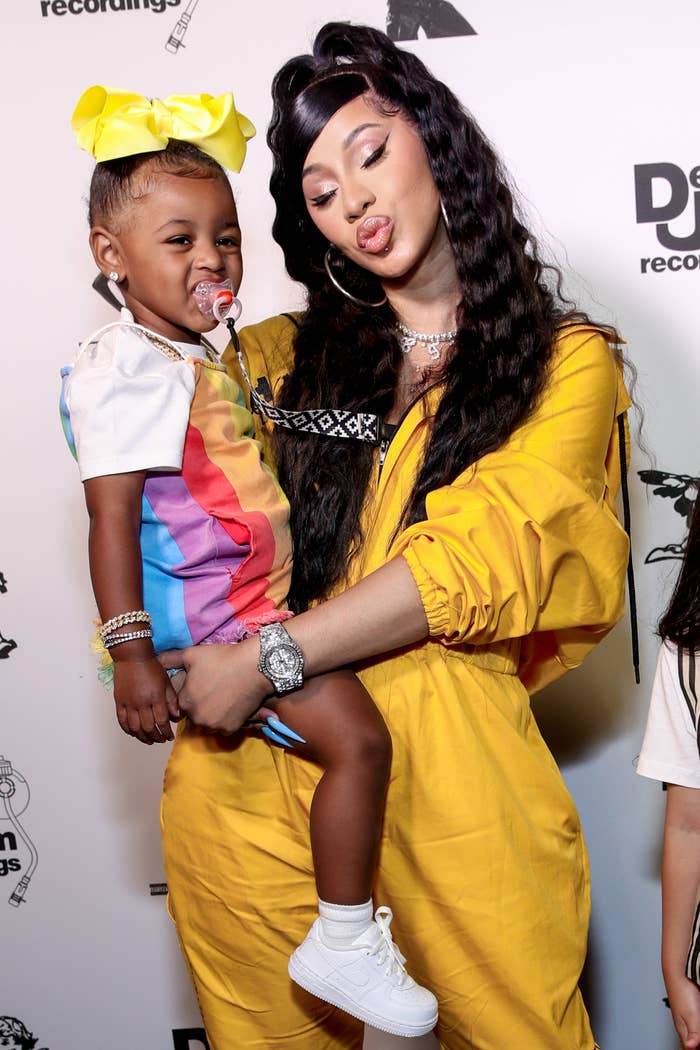 Cardi B puckers her lips to make a kissy face pose while holding her daughter