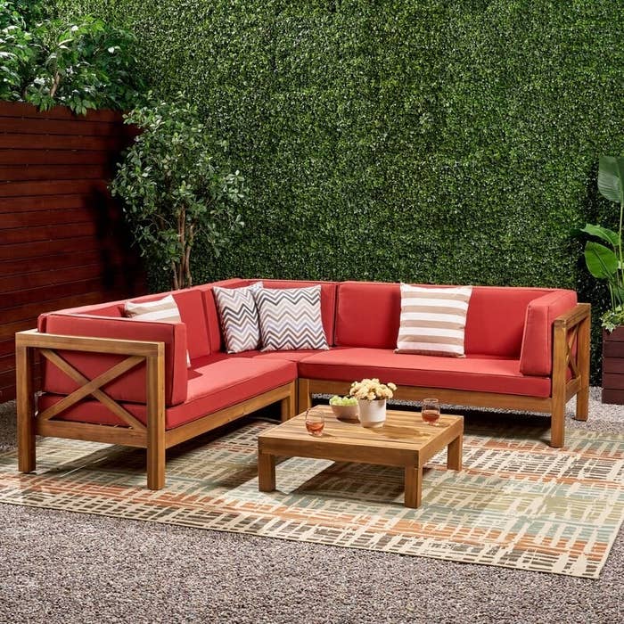 A four piece outdoor sectional with red cushions