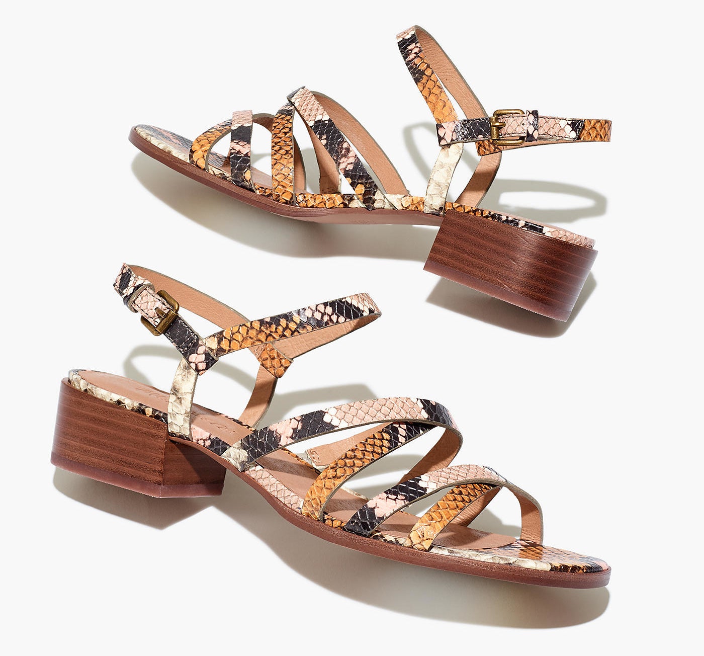 Strappy sandals with a small chunky heel and buckle back in a black, white, pink, and orange snakeskin print