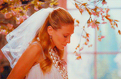 Carrie shrugs in a wedding dress during a photo shoot 