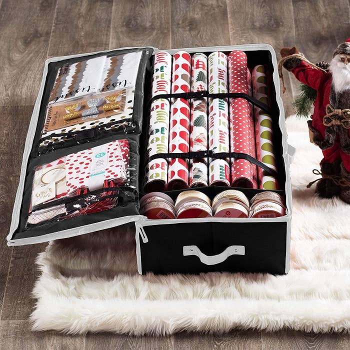 The gift wrap organizer filled with gift-wrapping supplies on a fuzzy carpet