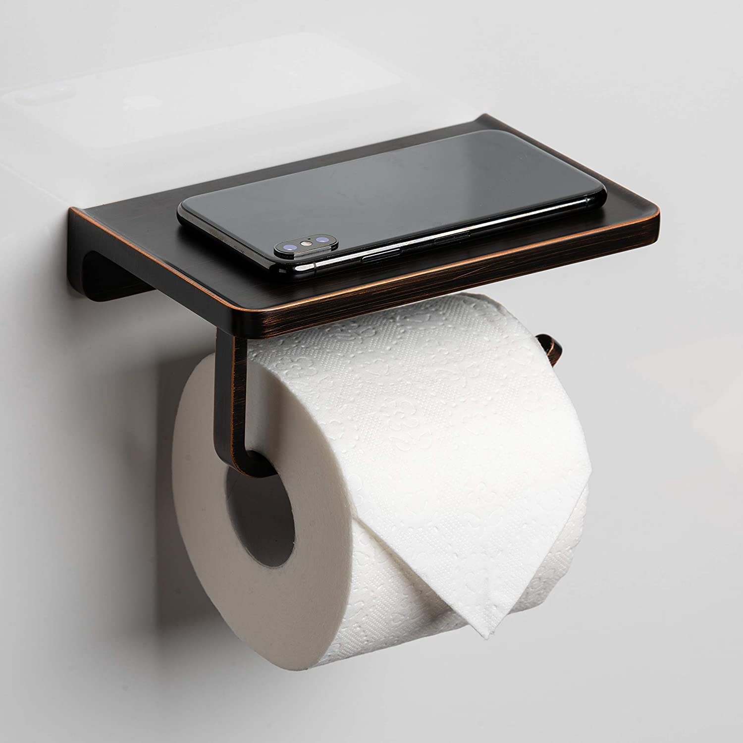 A toilet paper holder with a shelf on top