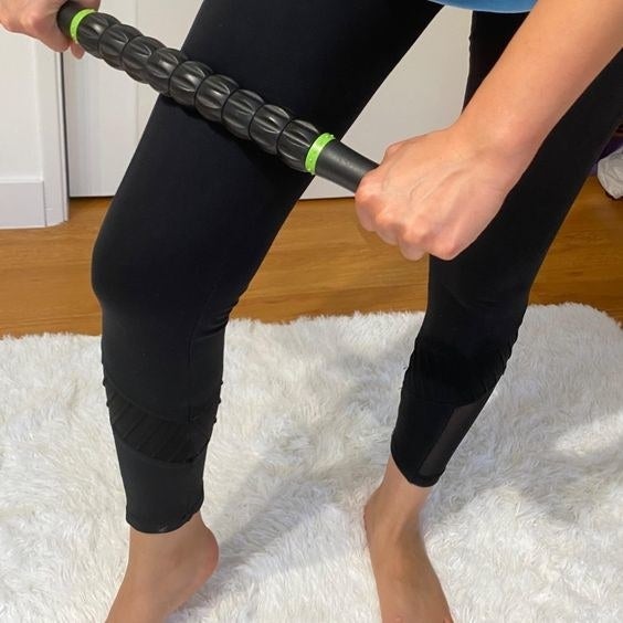 Reviewer using the muscle roller stick on their leg