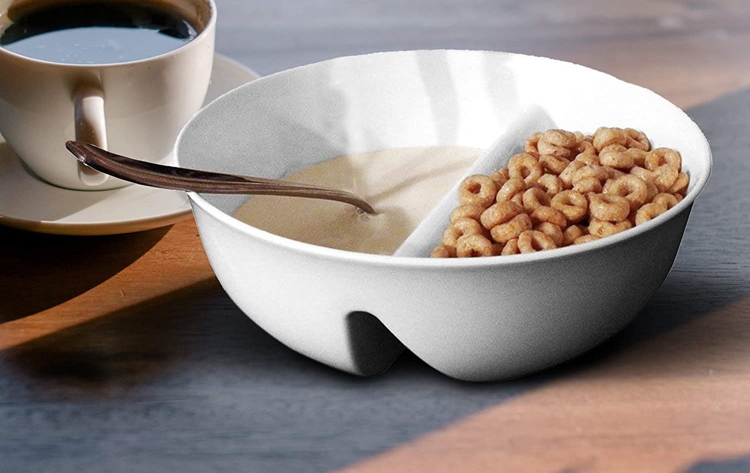 A bowl with milk in one compartment and cereal in another
