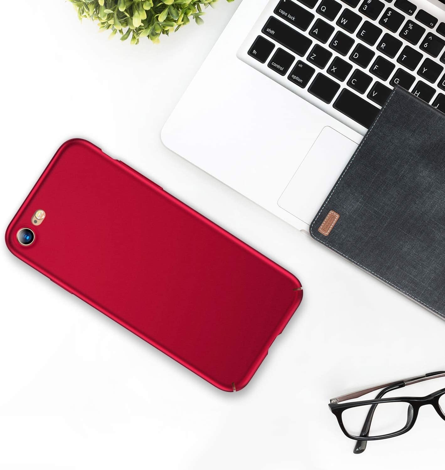 A phone with the case on lying next to a laptop on a desk