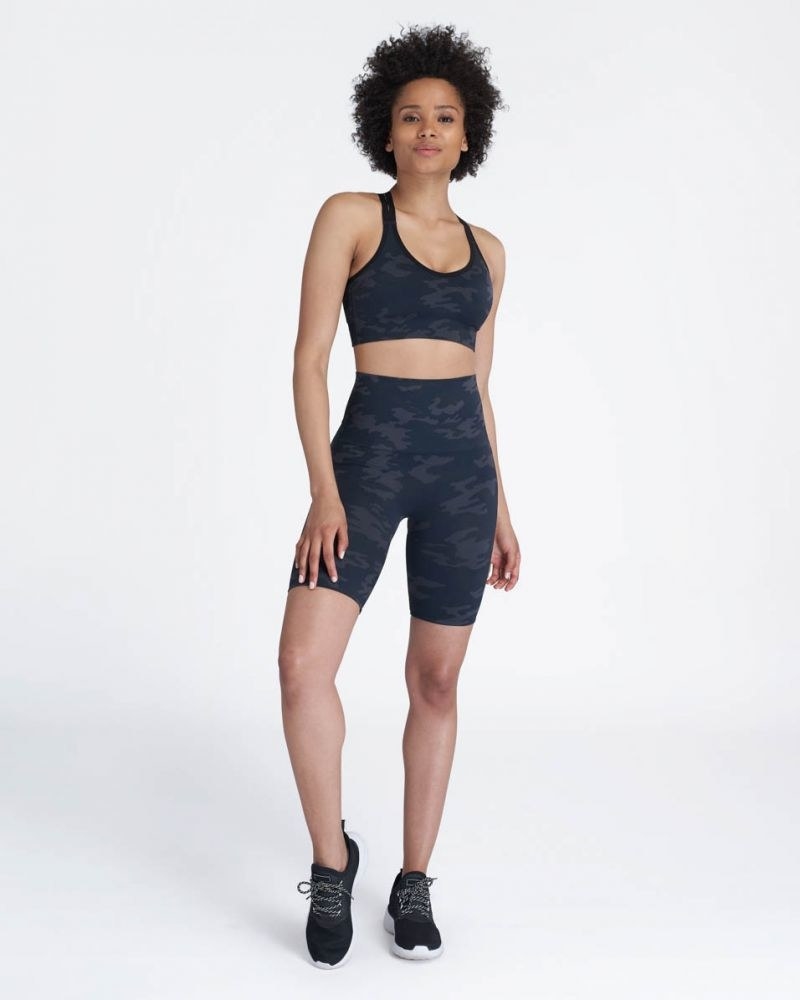 Model wearing the high-waisted bike shorts with a black camo print