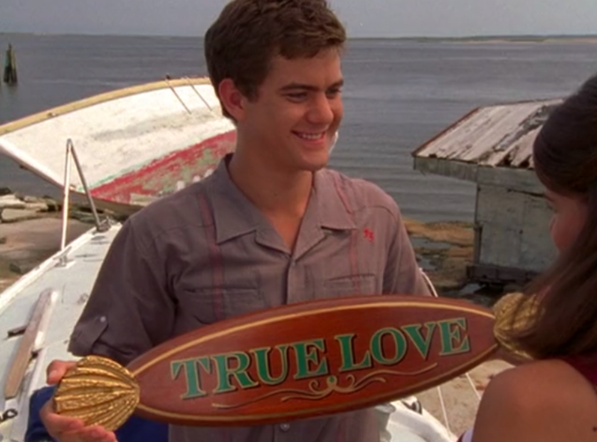 Pacey holds the &quot;True Love&quot; sign for his boat. 