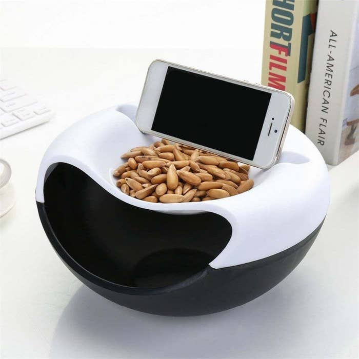 A bowl with nuts inside it and a phone on a built in phone mount