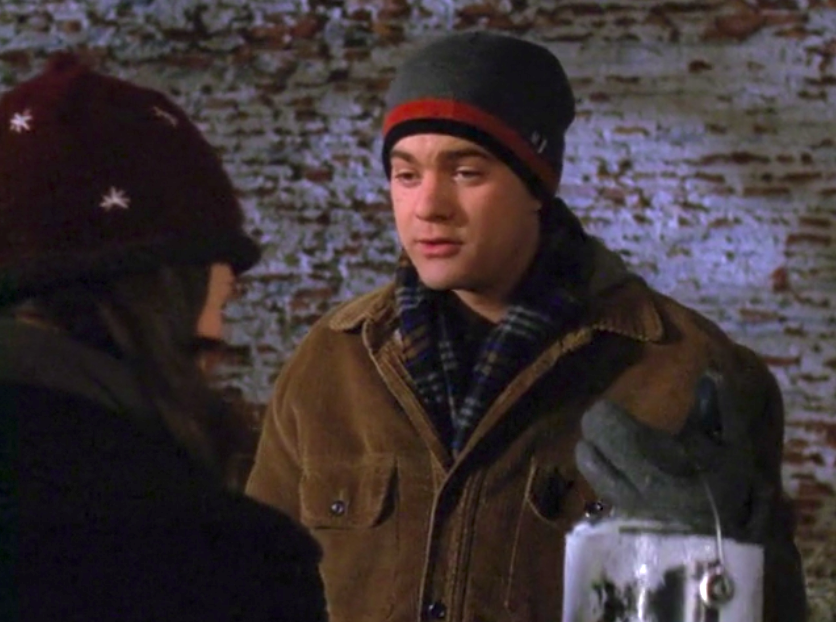 Pacey and Joey stand in front of a brick wall that he bought her.