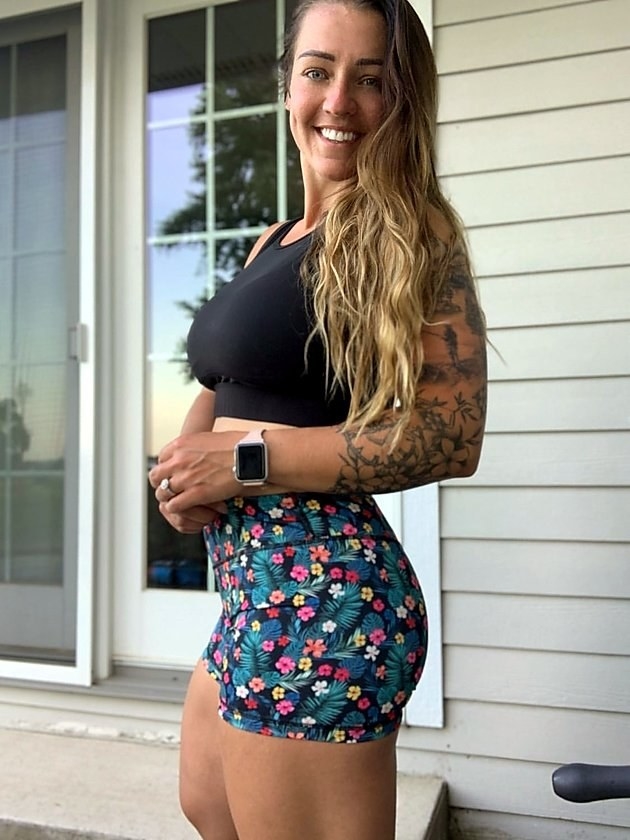 Model wearing the mid-rise tight shorts in a tropical floral pattern