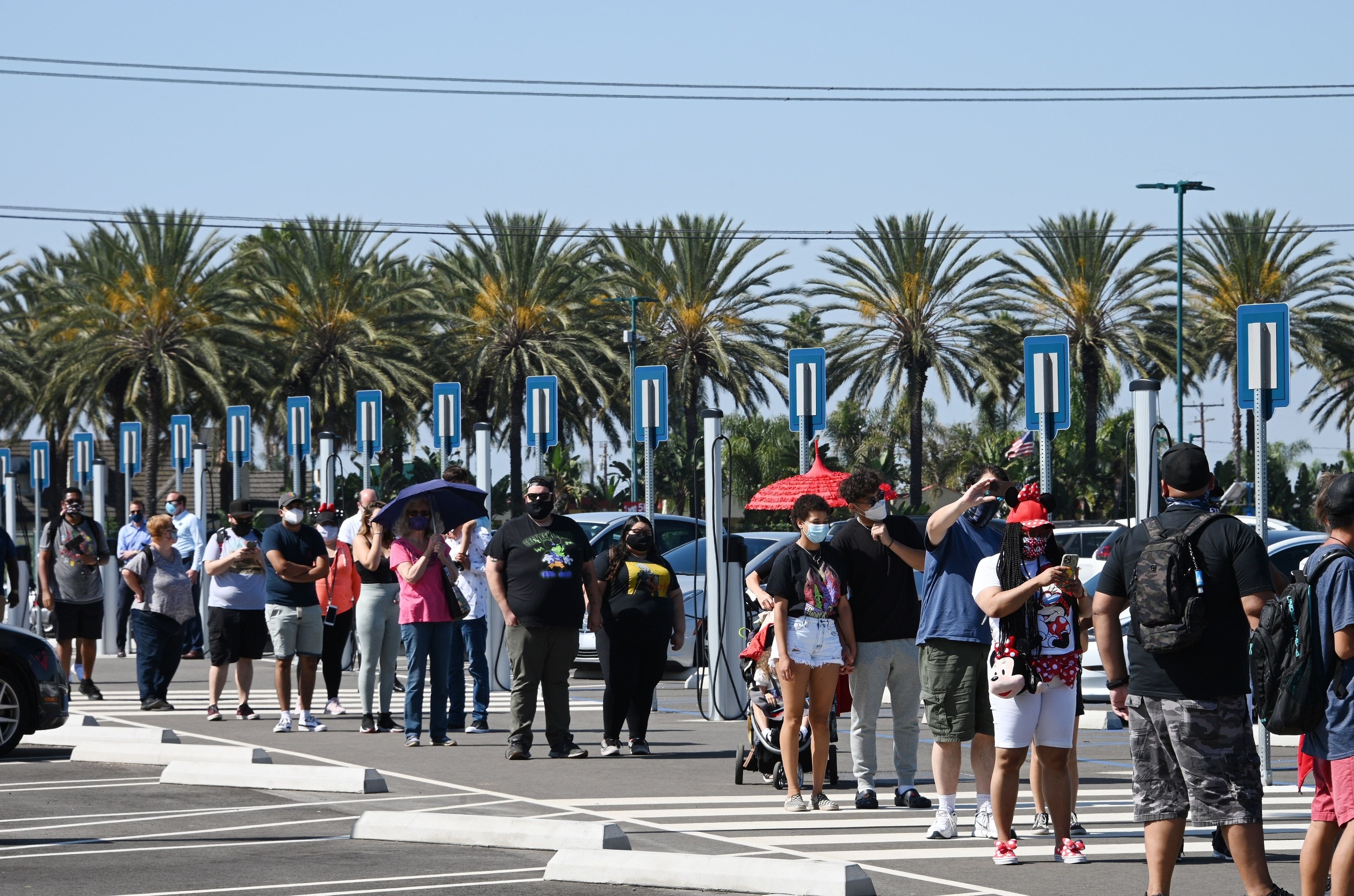 A long line of people in masks waiting to enter Disney Downtown District