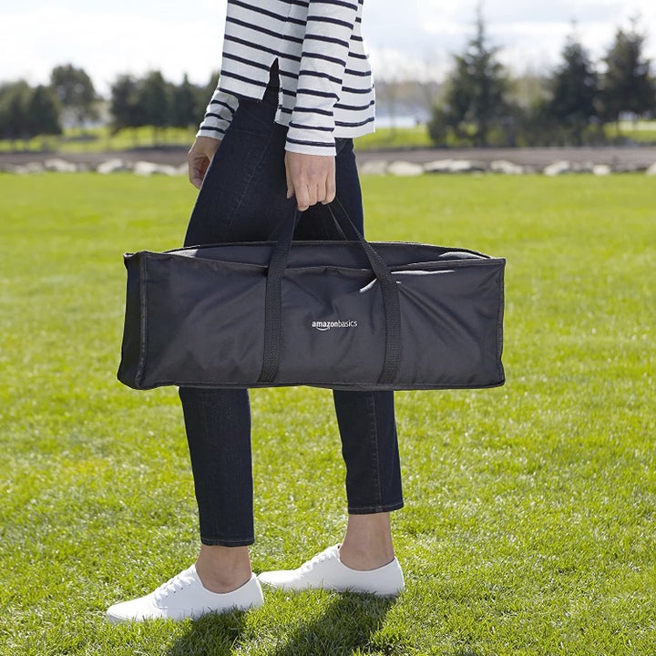 Model carrying the ladder toss game in a black case

