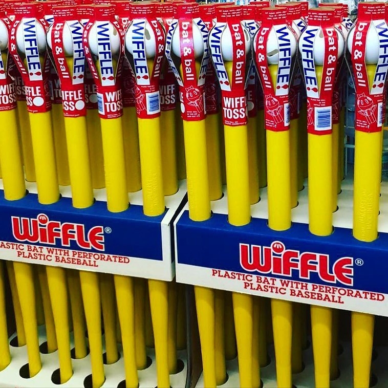 An instore display of class Wiffle yellow bats and balls