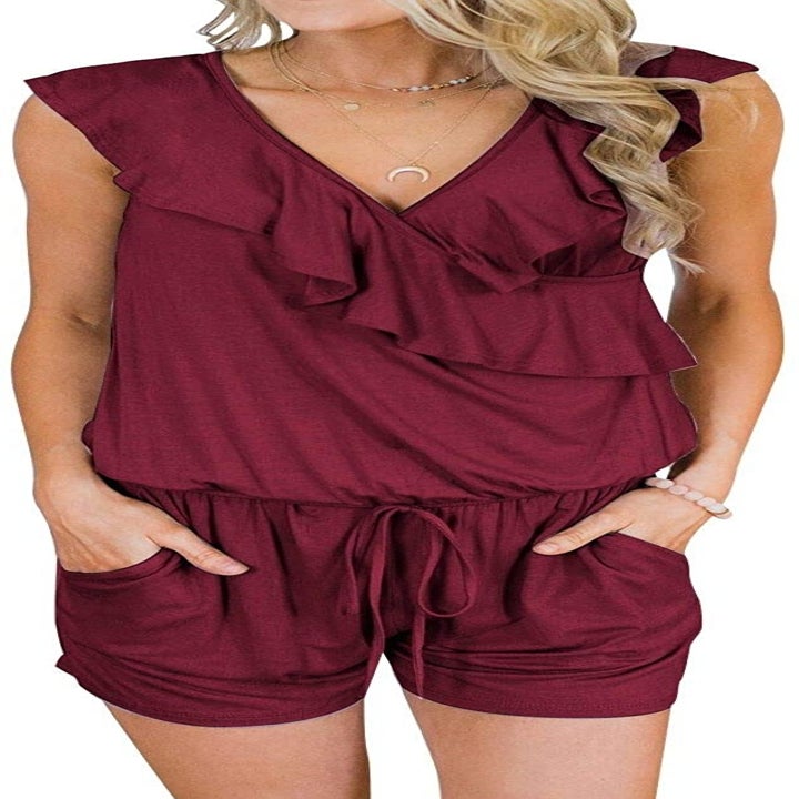 A model wearing the romper in red with their hands in the pockets