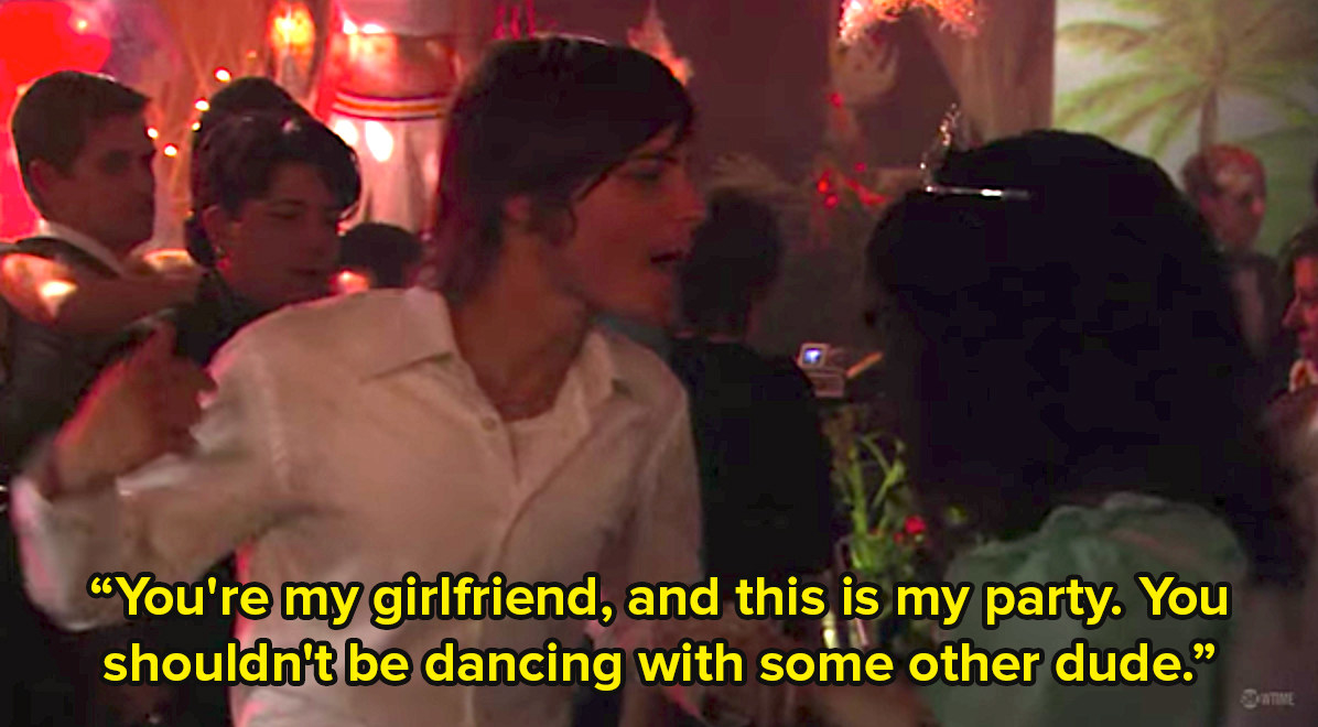 一个跨性别男子在一个派对上抓住一个女人的手臂说你是我的女朋友，这是我的派对，你不应该和其他男人跳舞