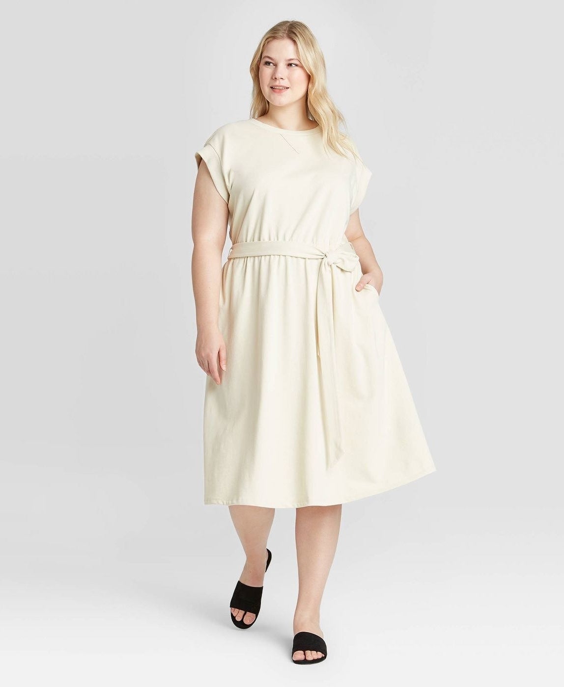 model wearing high-neck cream midi dress with tie waist