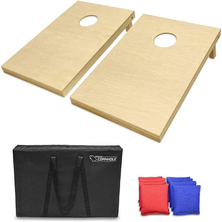 Two wooden cornhole boards with a black carrying case and four red and blue bean bags