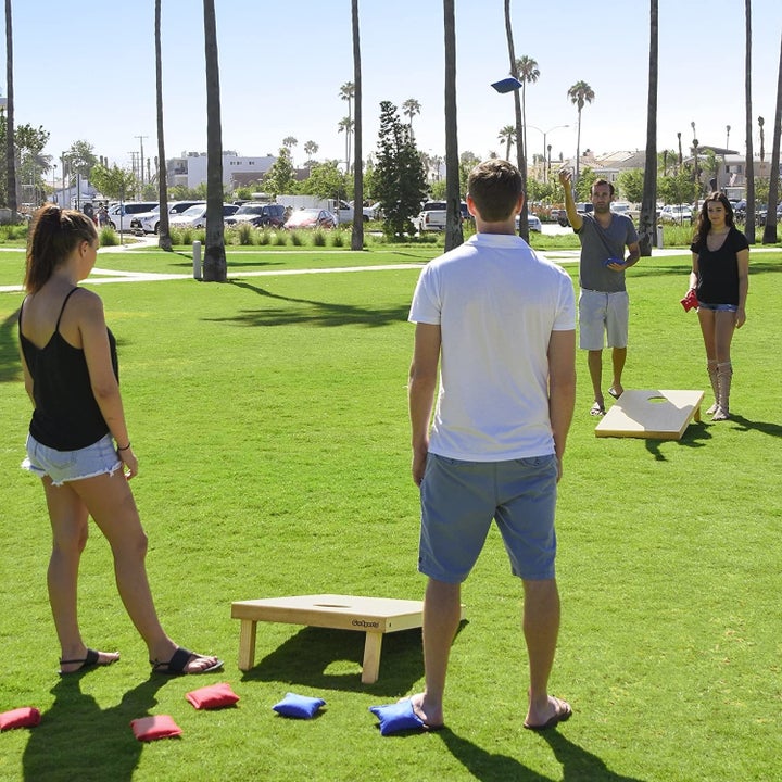 Four models playing with corn hole boards 