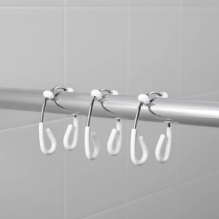 Three curtain hooks on a shower rod to demonstrate their shape