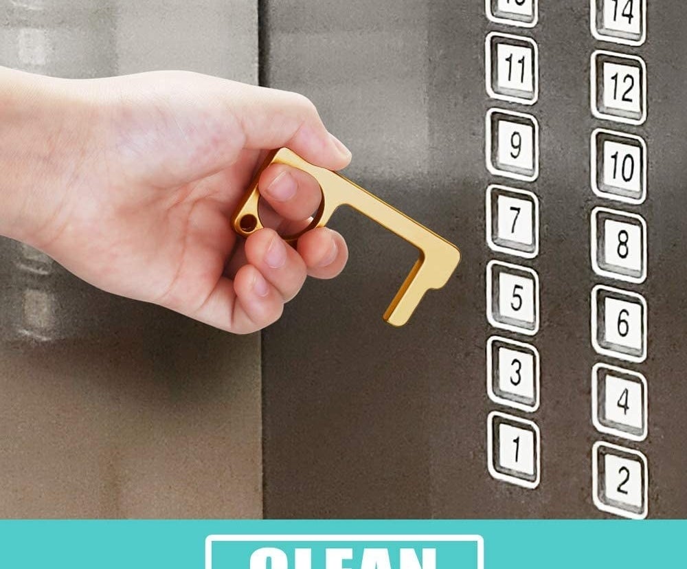 A person holding the tool while getting ready to push an elevator button