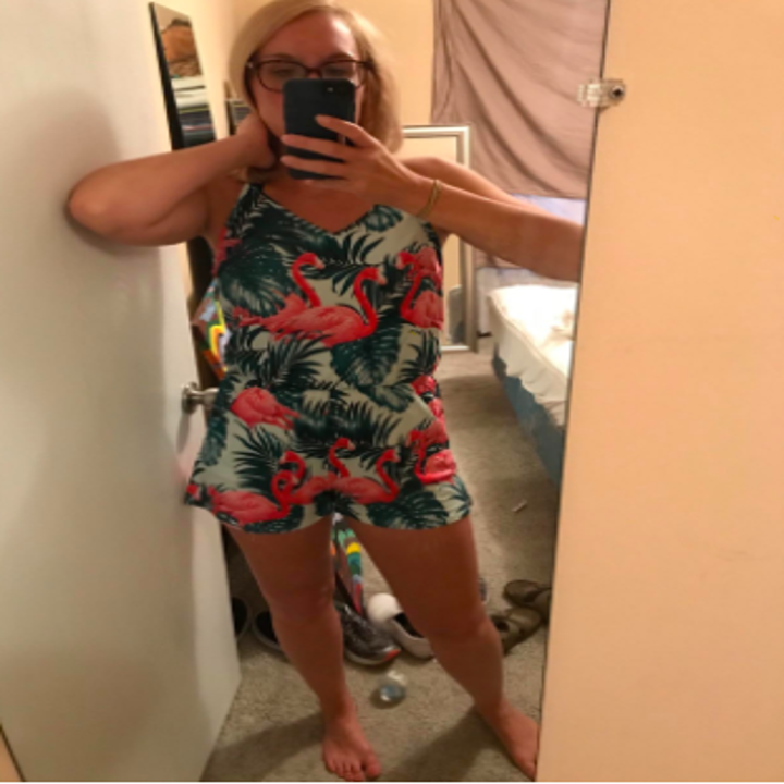 A reviewer wearing the romper in the flamingos and leaves print