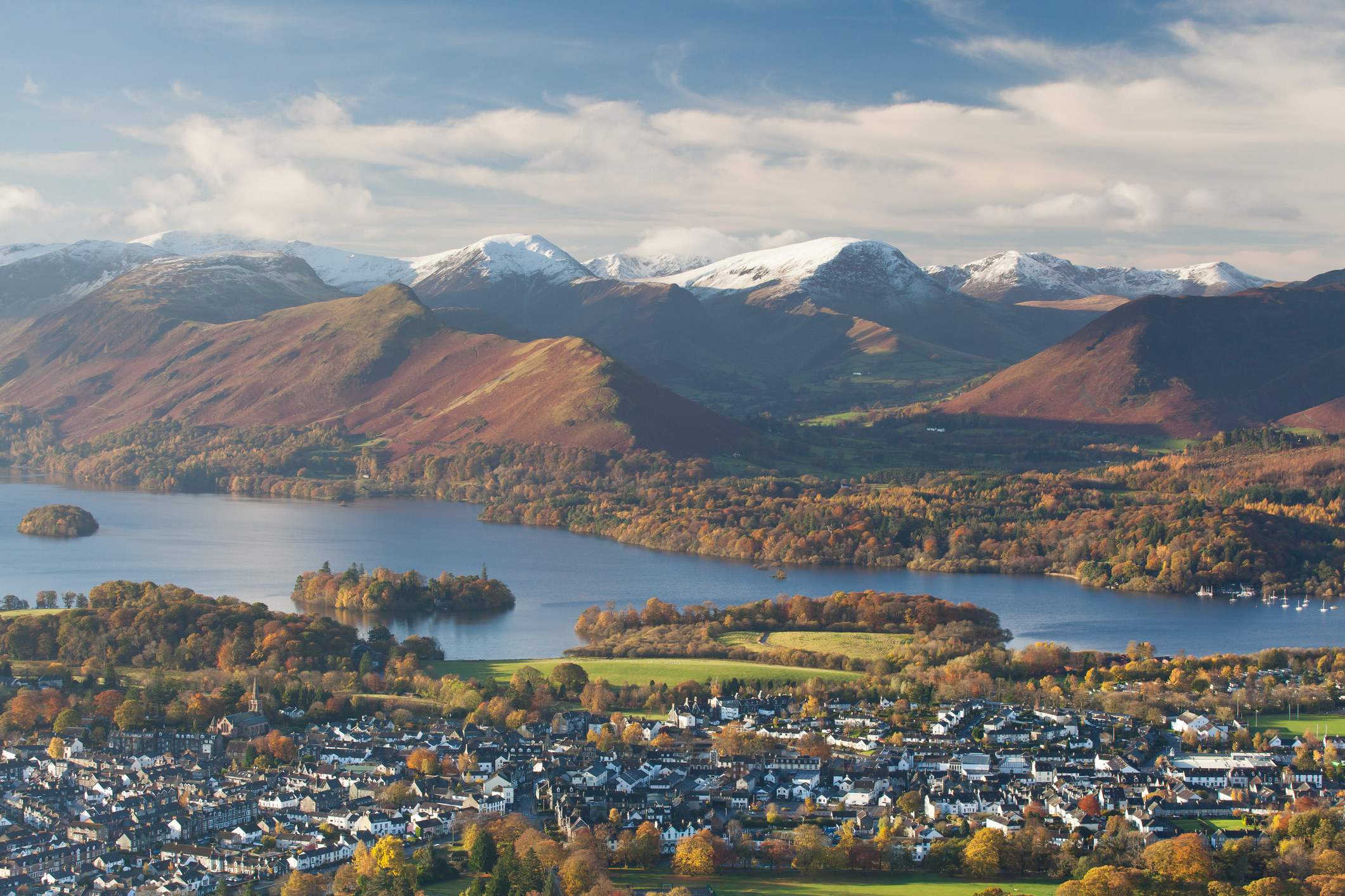 A view across the town of Keswick from above with the snow-capped mountains in the background