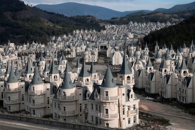 village of castles all identical with light grey bases and dark grey roof&#x27;s in the base of a valley