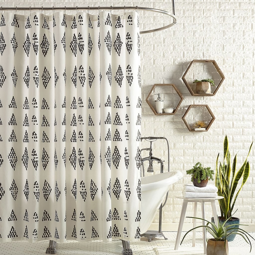 white shower curtain with irregular black dots forming a small diamond print