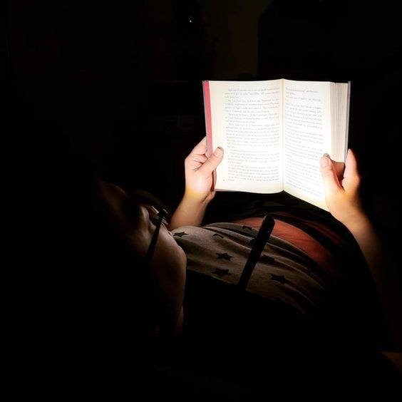 Reviewer using the bright reading light to read in the dark