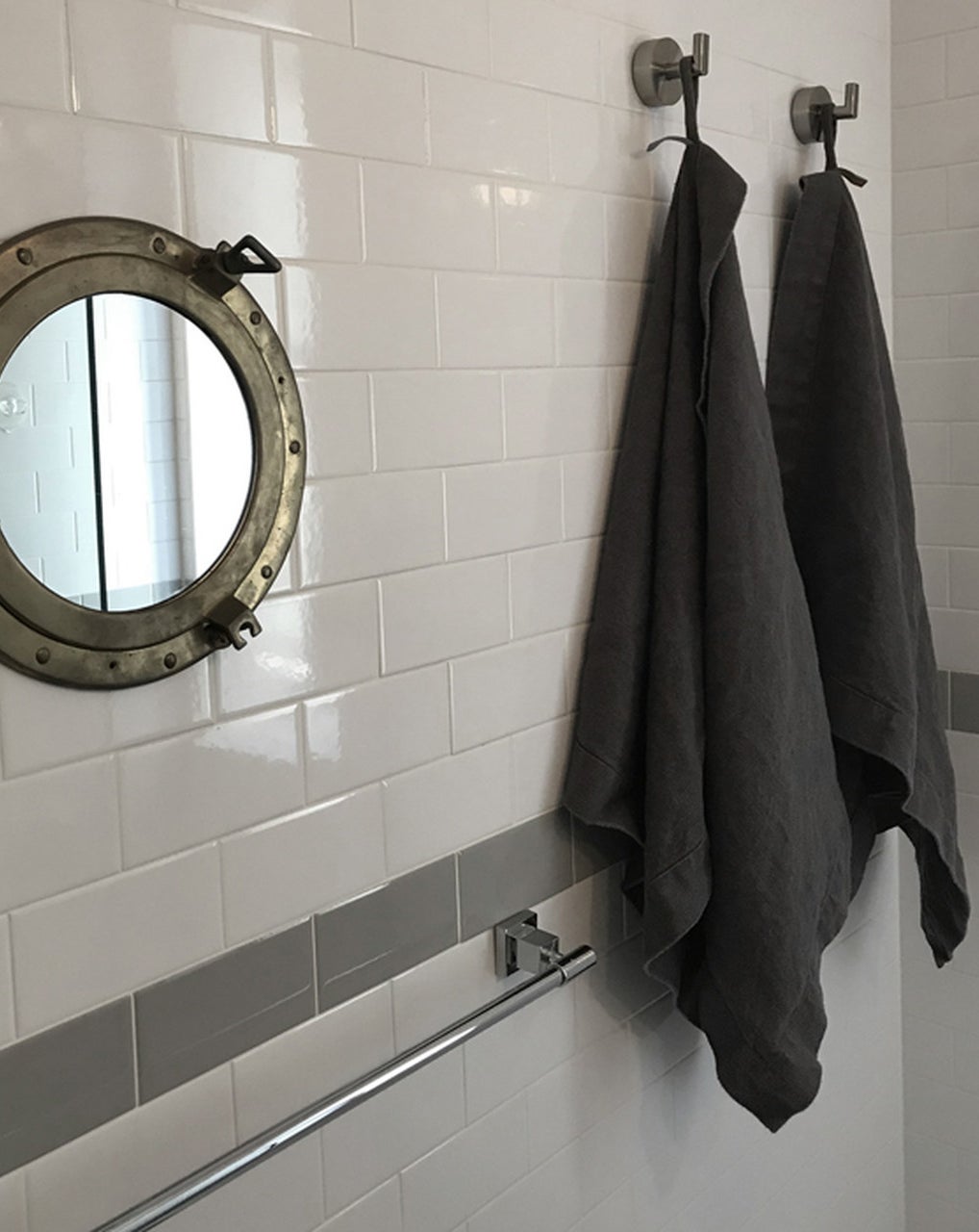 two dark grey linen bath sheets hangin on hooks