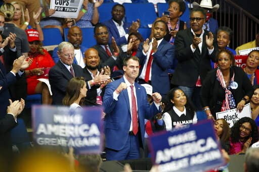 Gov. Kevin Stitt pumps his fists in the air while in the crowd at the president&#x27;s rally in Tulsa.