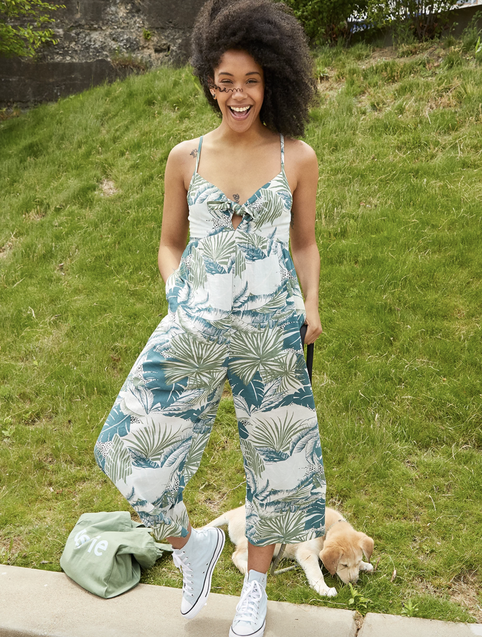 model wearing the white and green floral tank jumpsuit