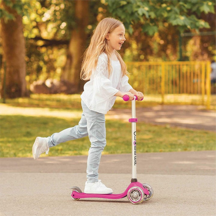 an older child scooting on the same scooter on their own
