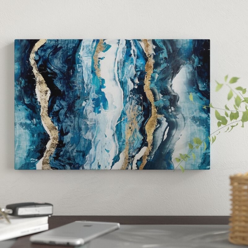 A blue, white, and gold marble art print hanging horizontally on a wall