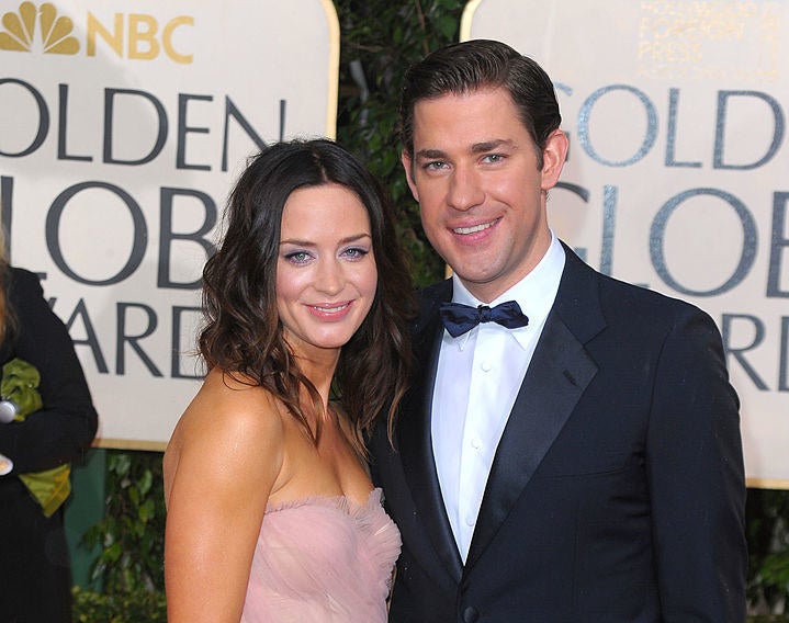 Emily Blunt in a pink dress hugging John Krasinski on the red carpet of the 2010 Golden Globes