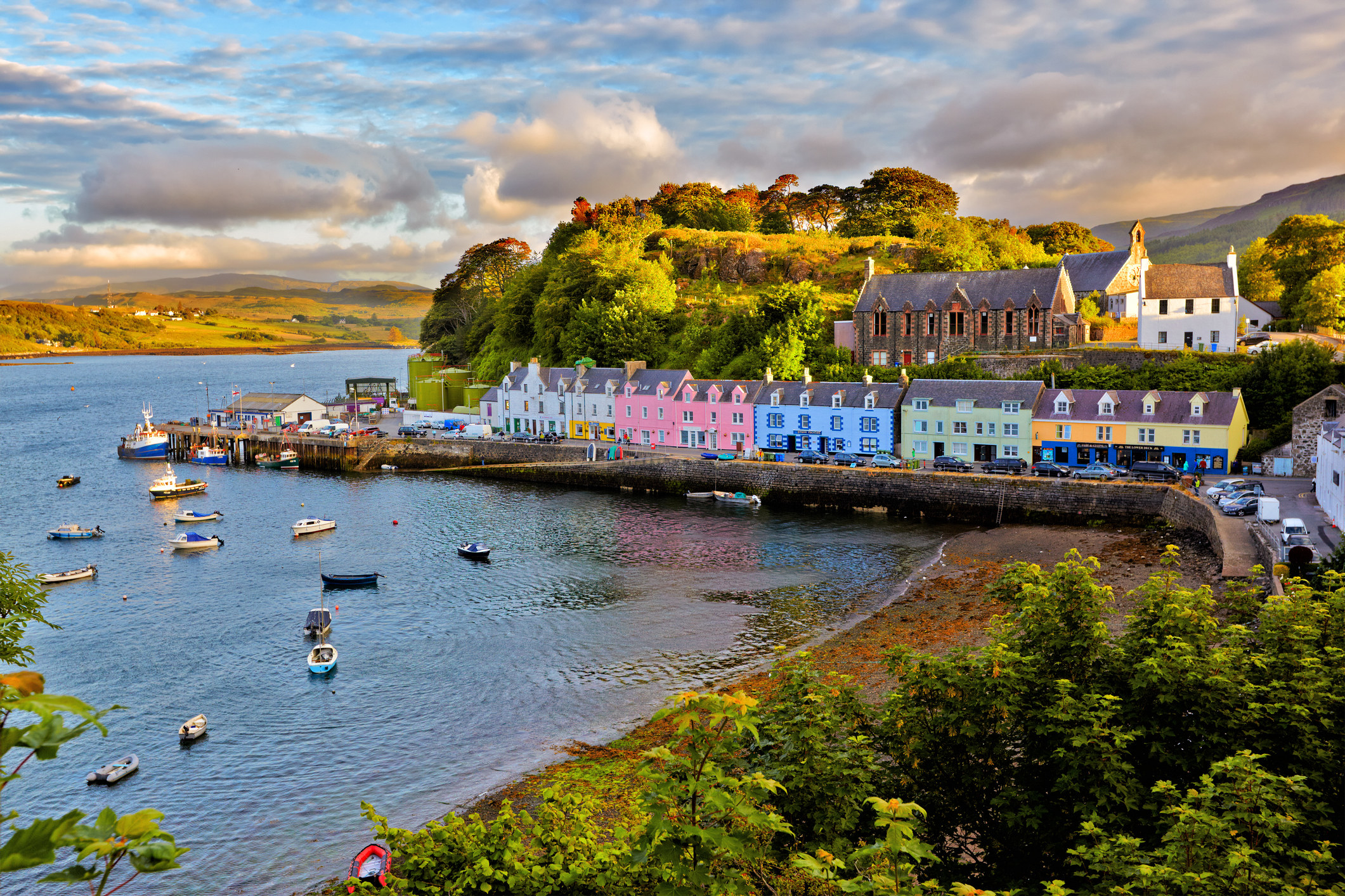 The bay of Portree with the village&#x27;s colourful houses sat on the coast road