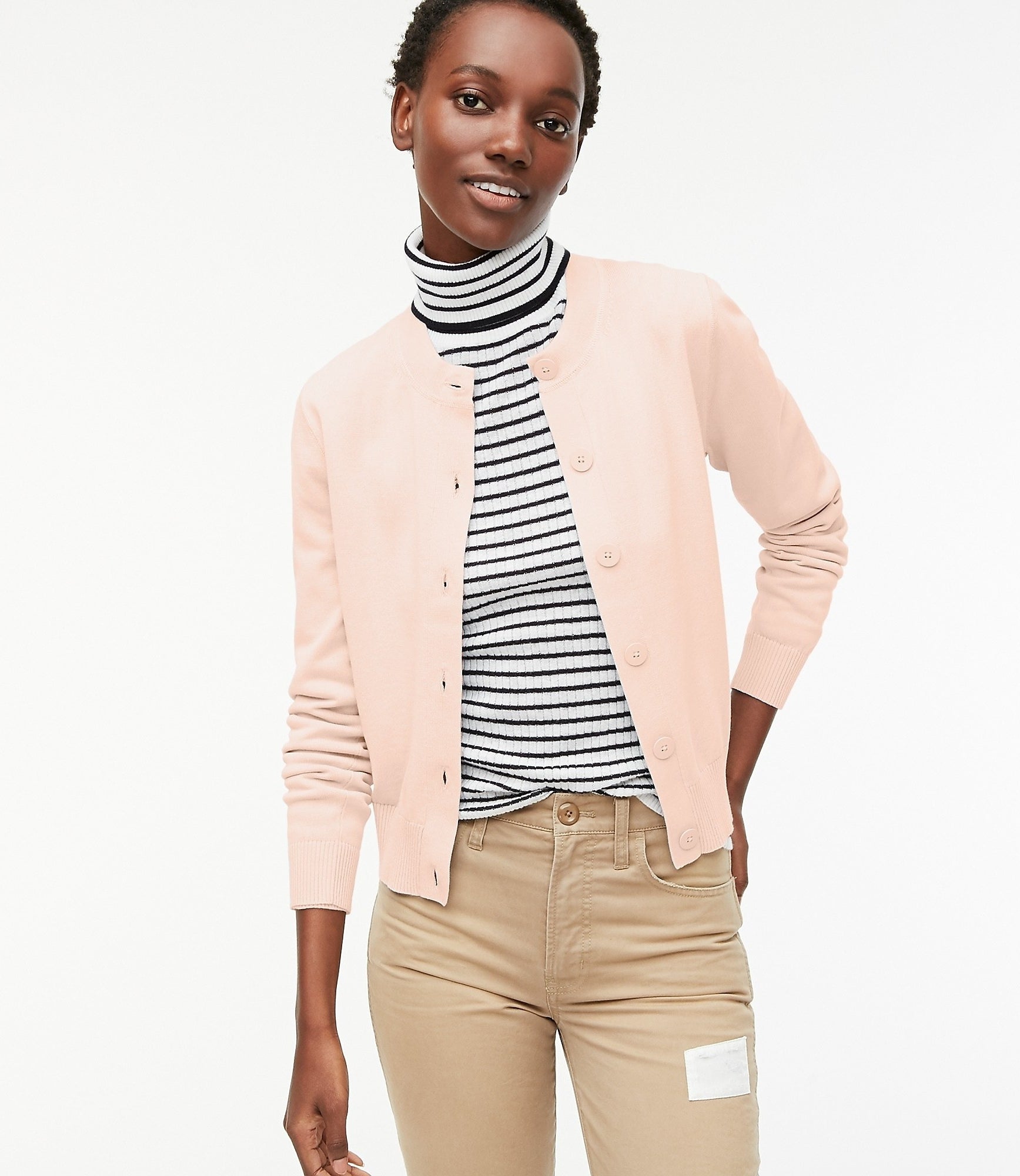model in blush pink cardigan with round neck and big buttons