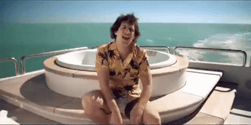 Andy Samberg in the music video for &quot;I&#x27;m on a boat&quot; on a yacht waving around some flip flops