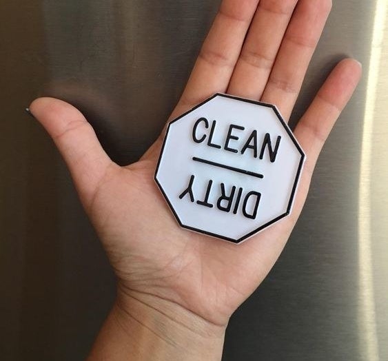 Reviewer holding the dishwasher magnet with one side for &quot;clean&quot; and one side for &quot;dirty&quot; 