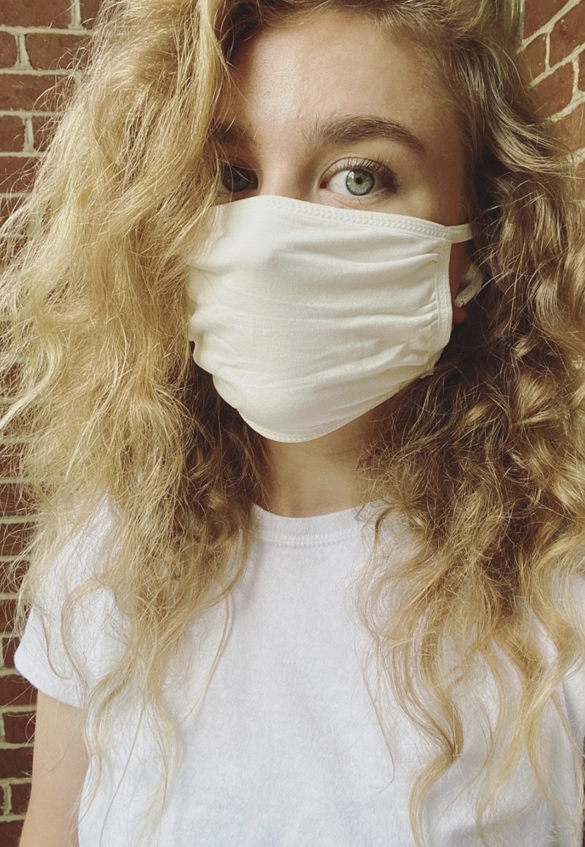 A BuzzFeed editor in a white cotton face mask