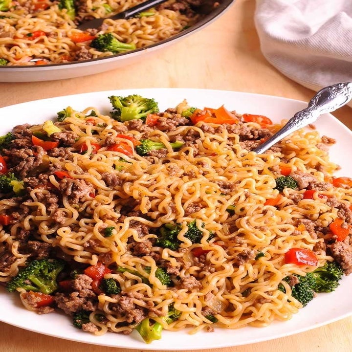 A plate of stir-fried ramen with veggies and ground beef.