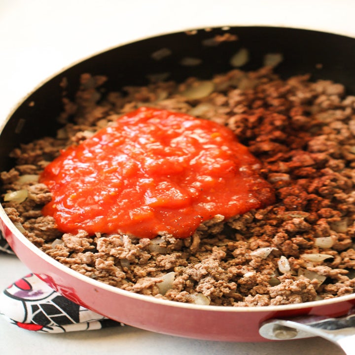 A skillet with ground beef and salsa.