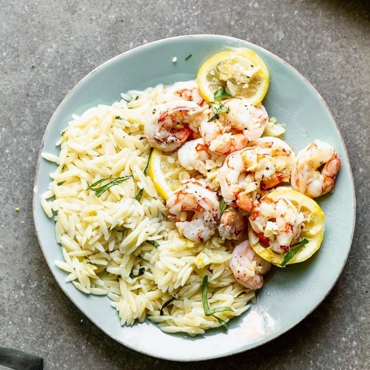 A plate of orzo with lemon garlic shrimp.