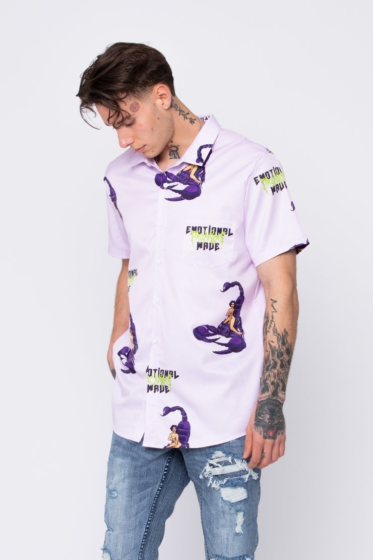 person wearing a light purple button up short sleeve shirt with a print that has a person sitting on a purple scorpion and &quot;emotional promise made&quot; print on it