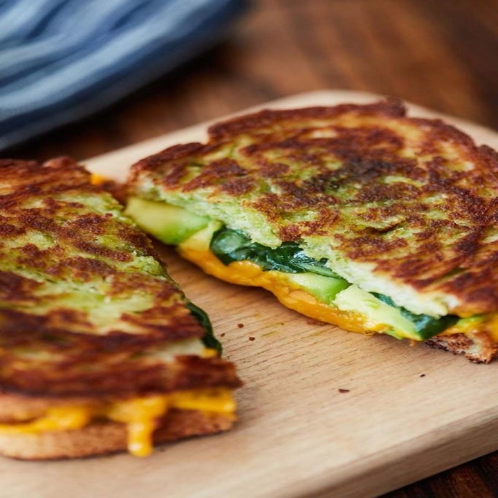 A grilled cheese sandwich stuffed wit spinach, avocado, and cheese.
