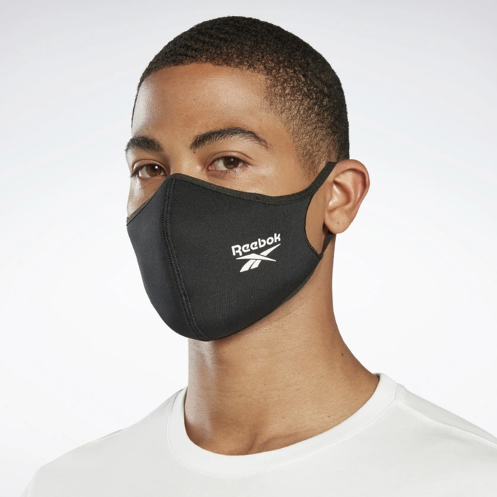 A model in a black Reebok mask with a logo 