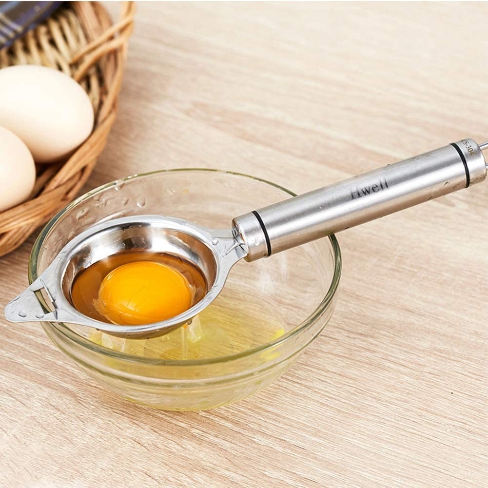 The separator placed over a bowl with the egg yolk in the center and the egg whites dripping into the bowl