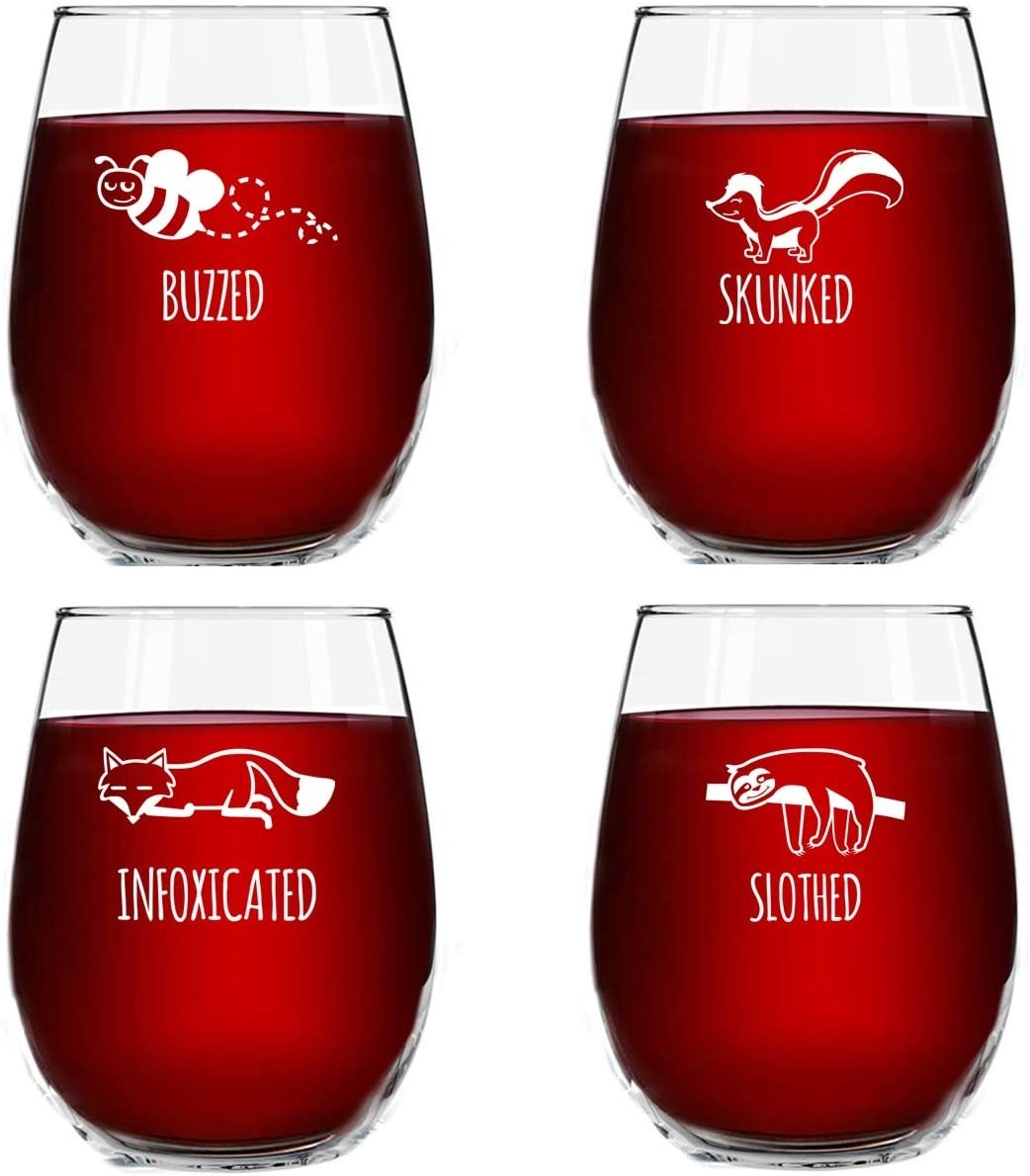 Four wine glasses one with a bee that says buzzed one with a skunk that says skunked one with a fox that says intoxicated and one with a sloth that says slothed